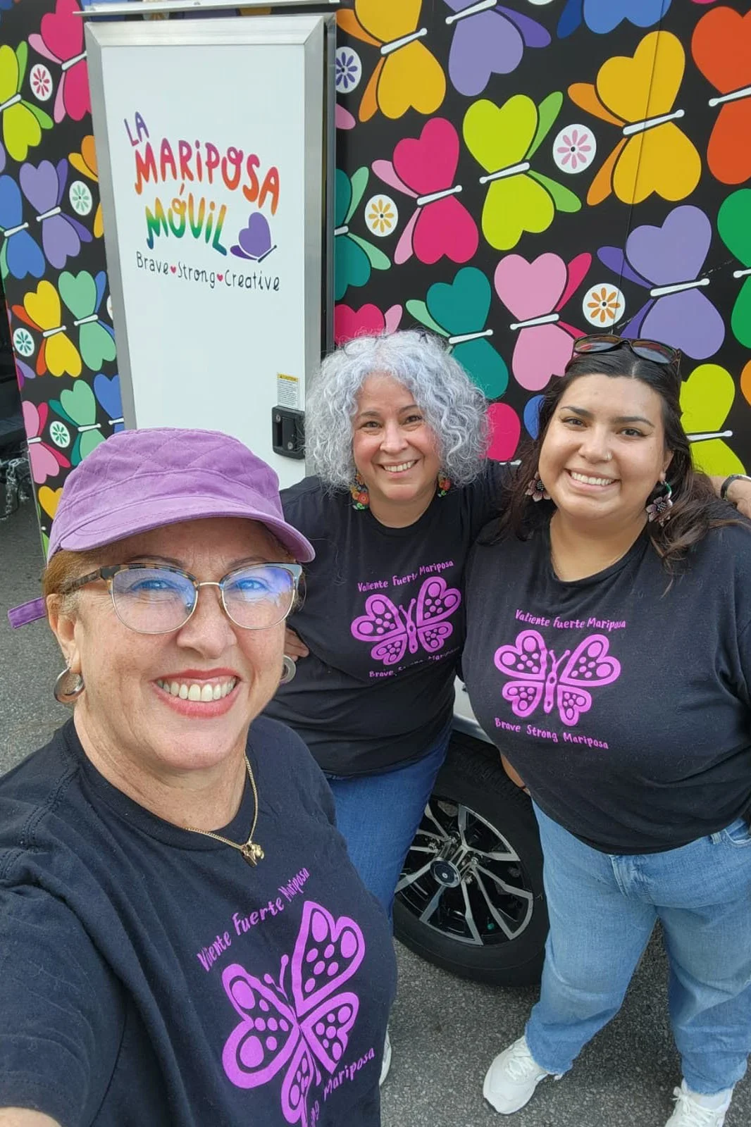Group of smiling latinas next to the art mobile