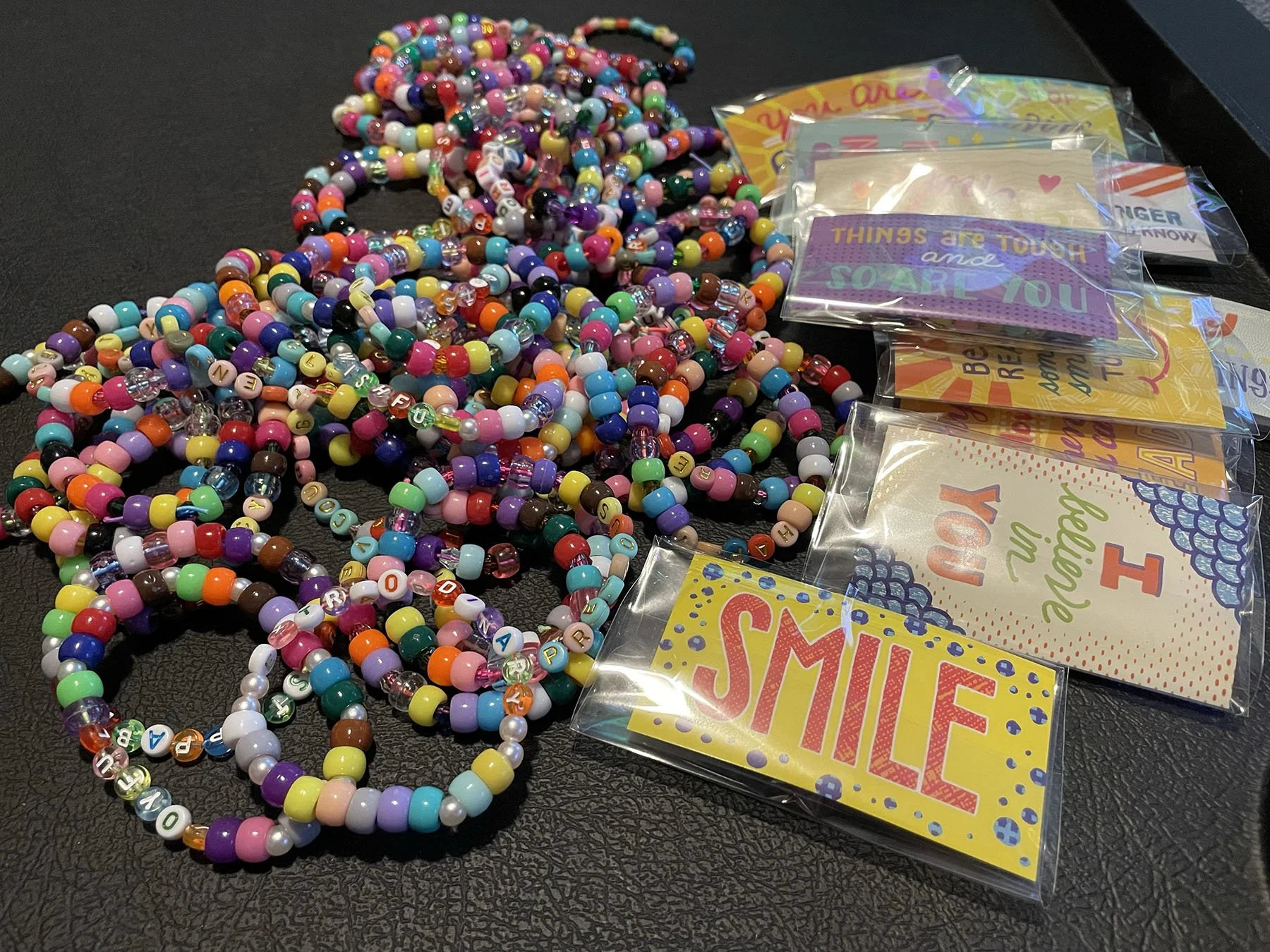 Group of colorful, beaded bracelets containing inspirational messages