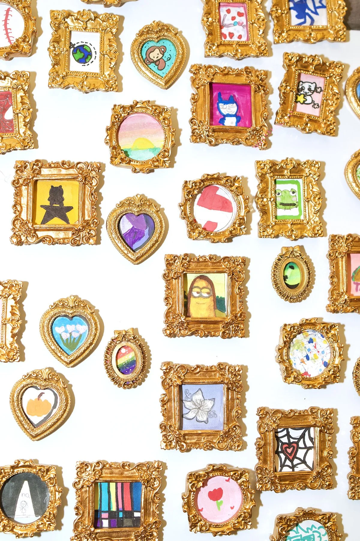 A gallery wall displaying illustrations in ornate gold frames