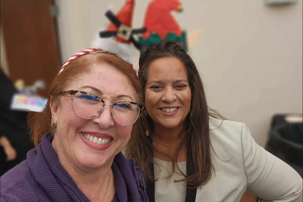 Two women wearing festive Christmas hats