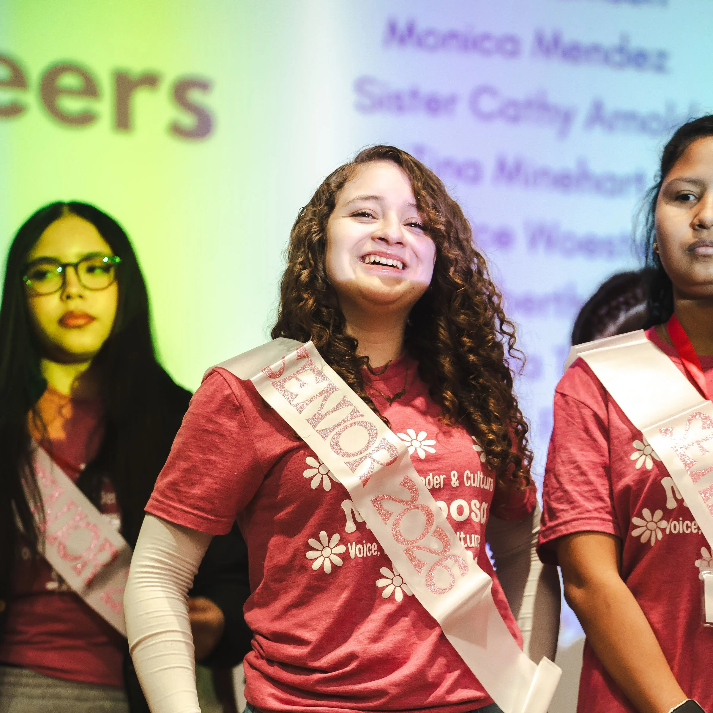 Smiling latina wearing a sash that says Senior 2026