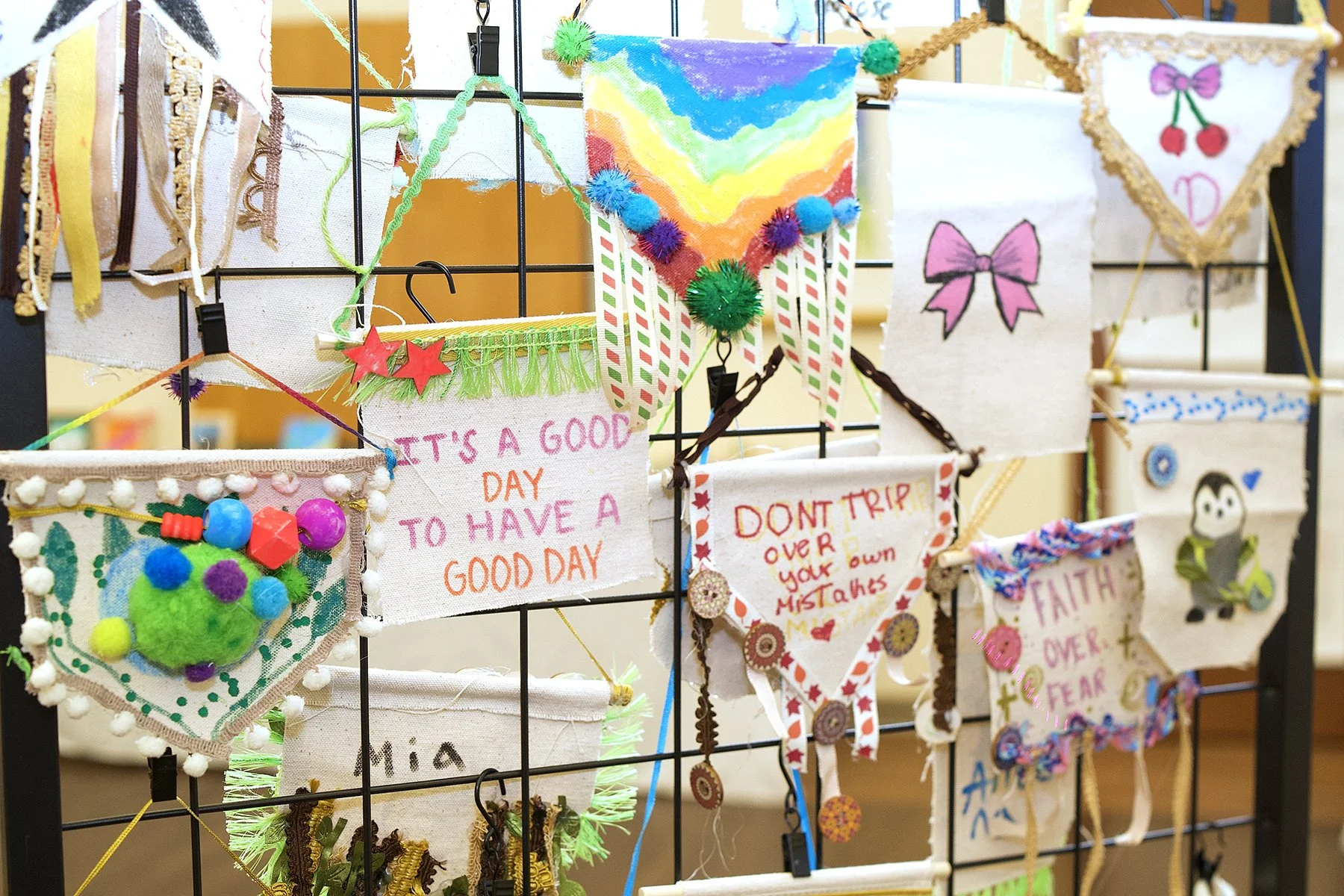 A wire dividing panel with handmade inspirational banners hanging