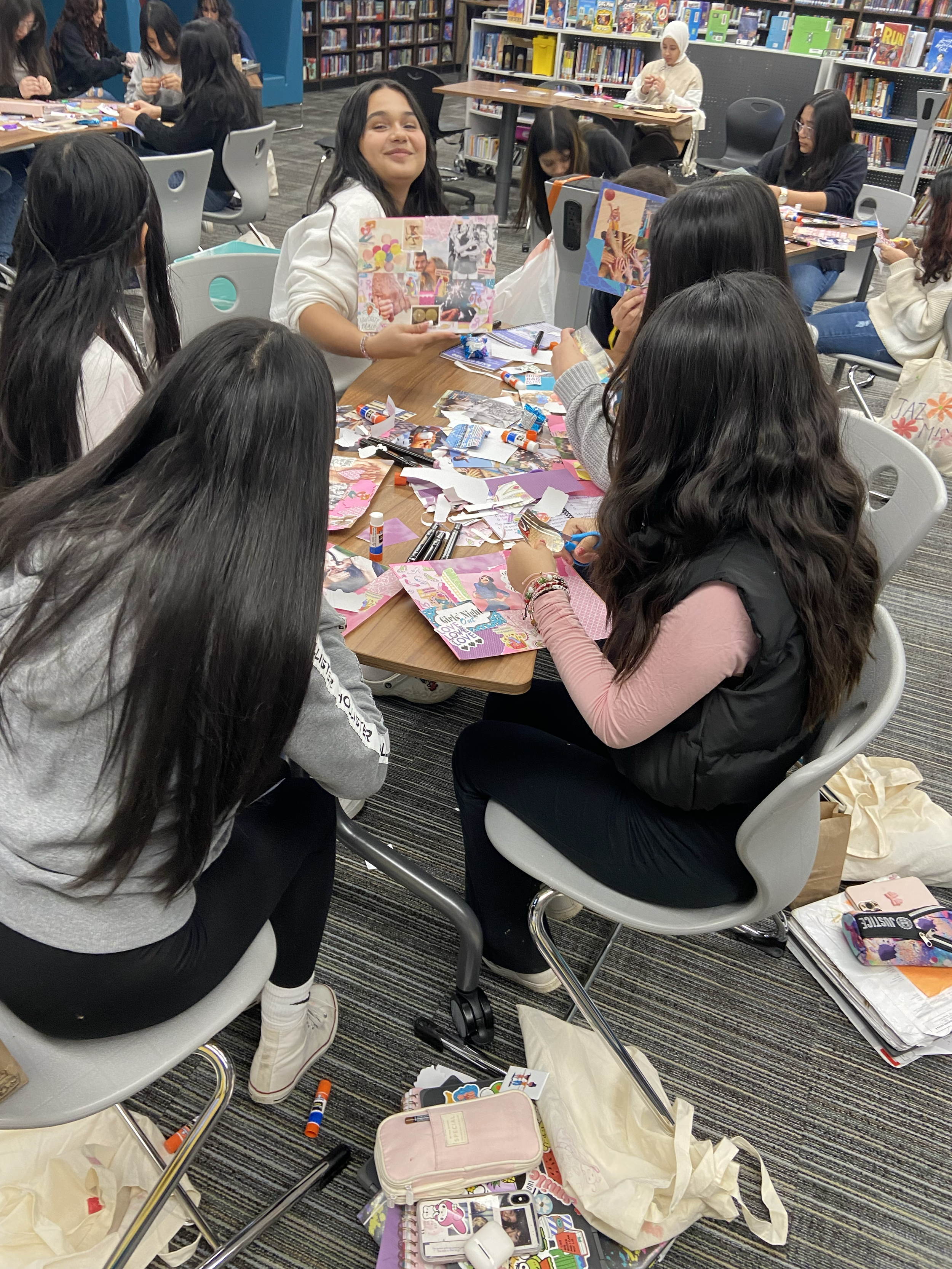 Group of Latina girls sitting at a table collaborating on a project