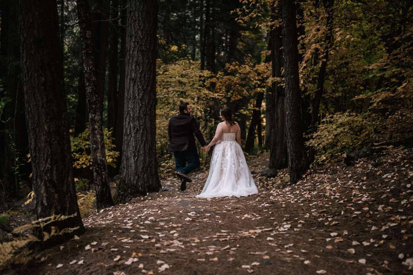 newly married husban clicks heels with joy fall yosemite elopement