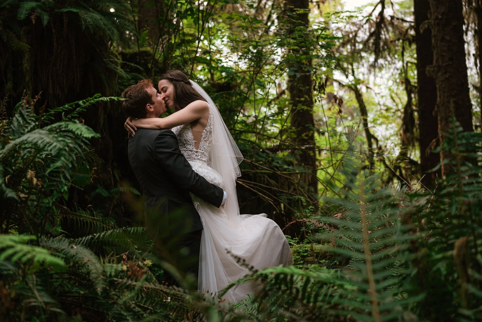 husband picks up new bride among ferns in hoh rainforest