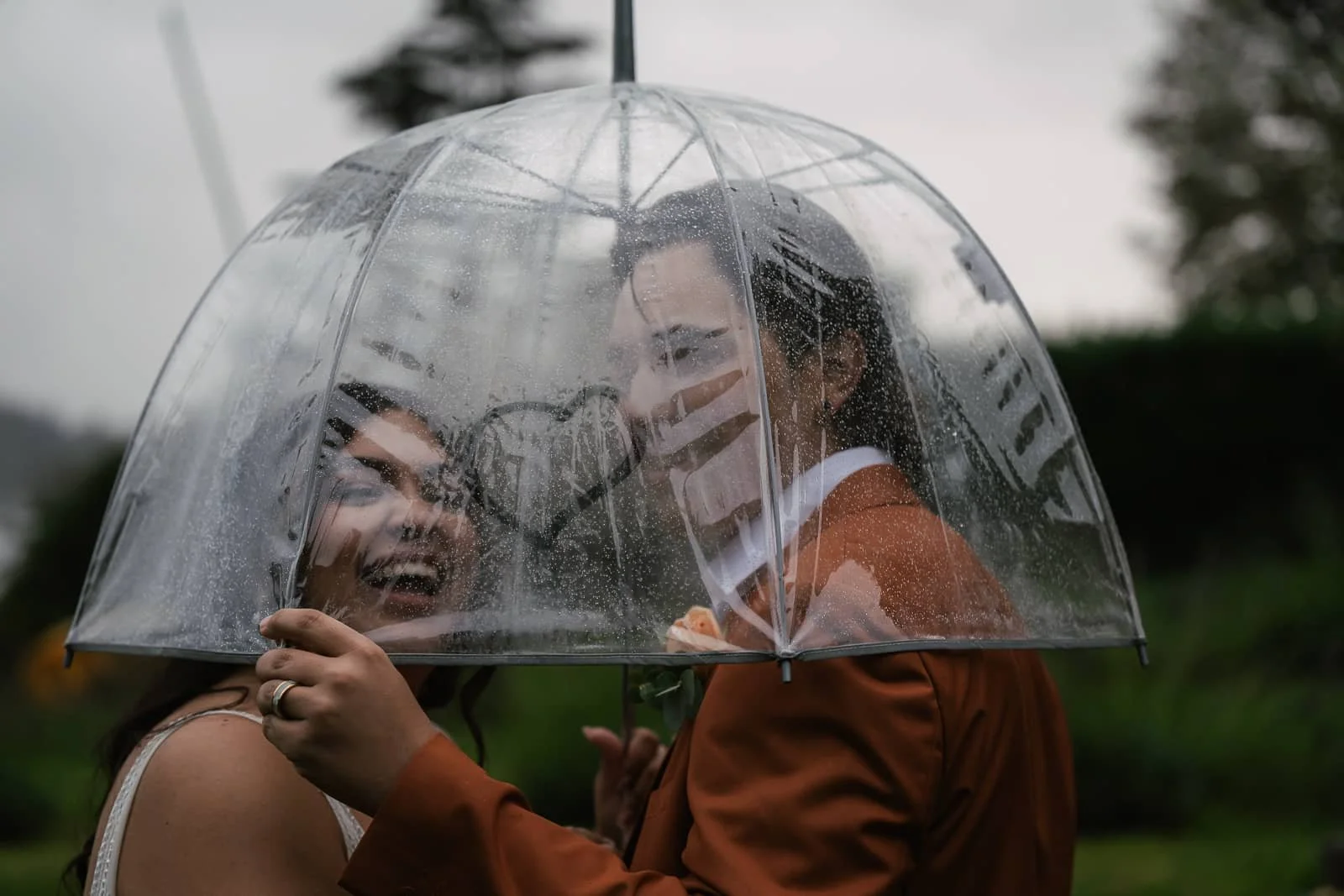Couple smiles at heart made in steam of umbrella