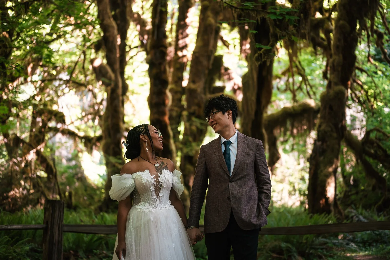 bride and groom smile at each other in the maple grove