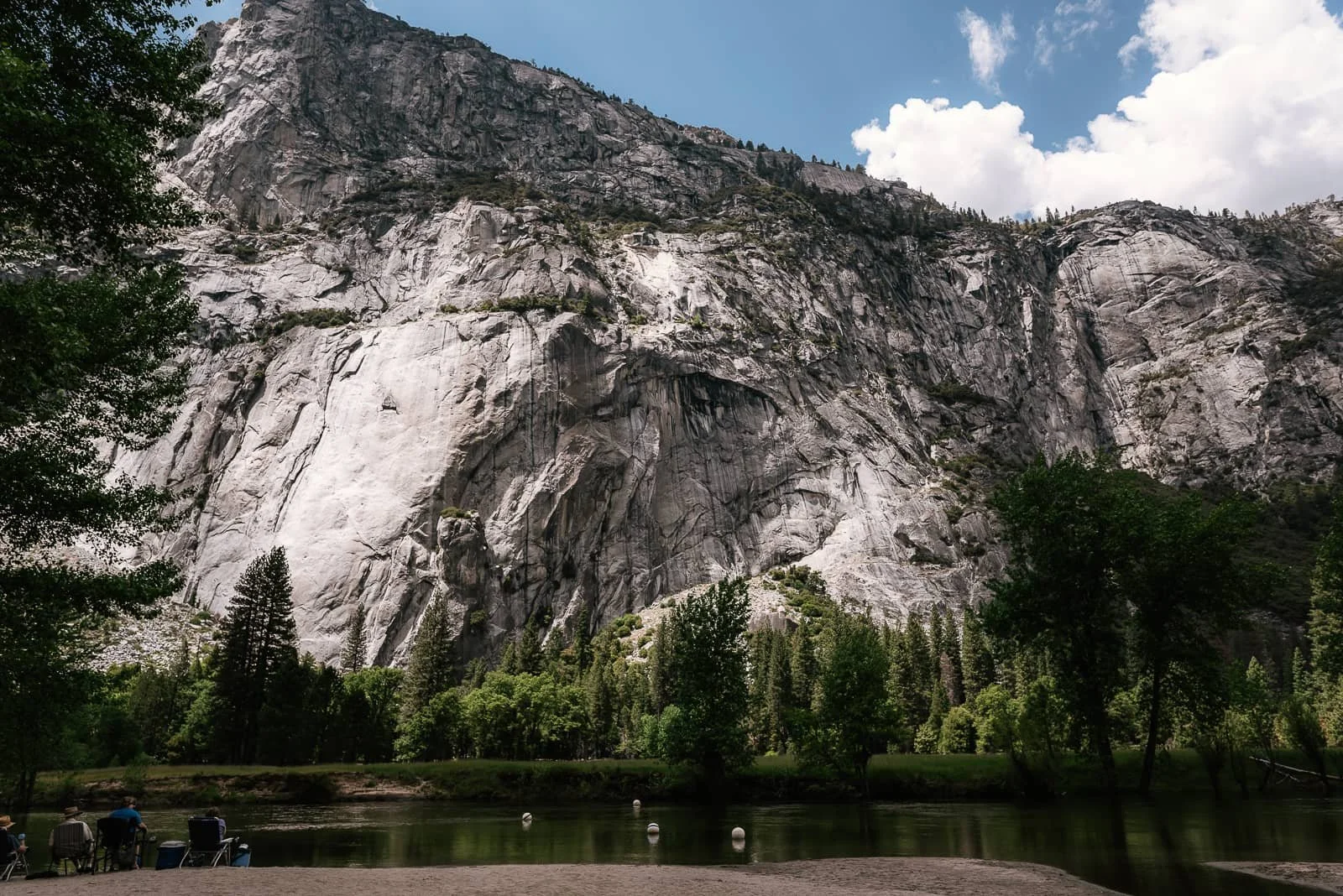 Granite cliff rise high into the sky across the Merced river.