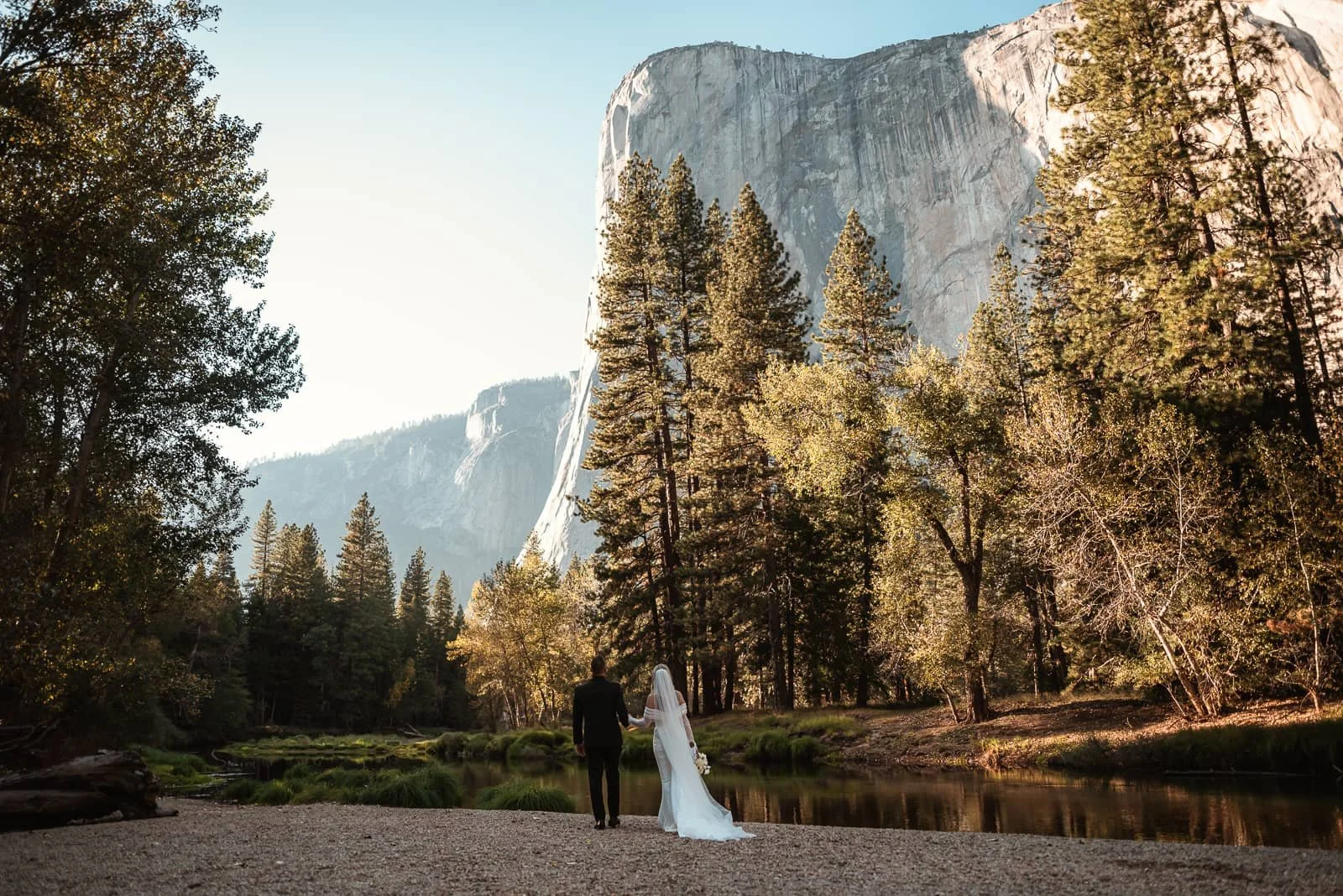 couple looks up at sunlit el capitan in yosemite