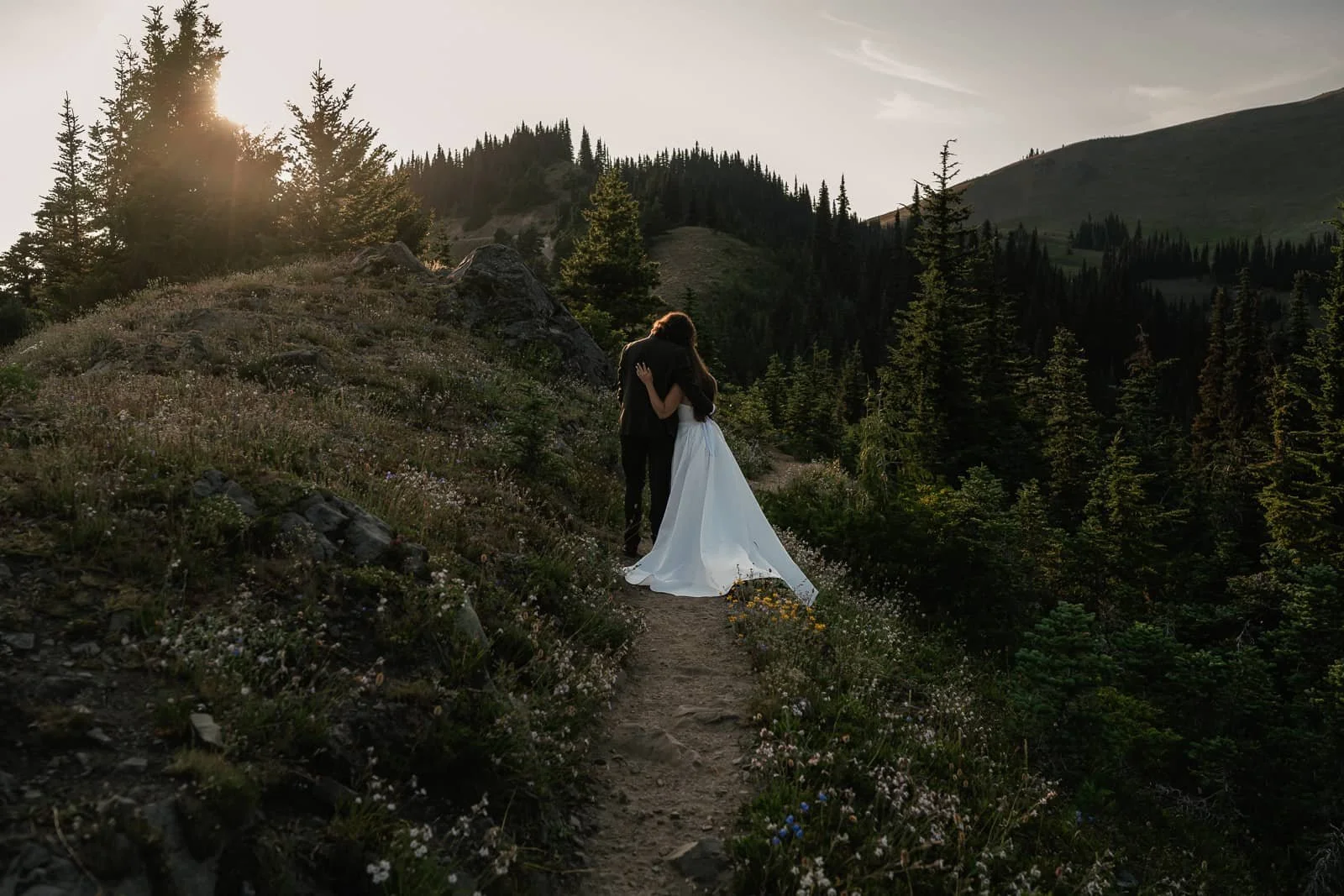 sunset light falls on couple on hiking trail to hurricane ridge