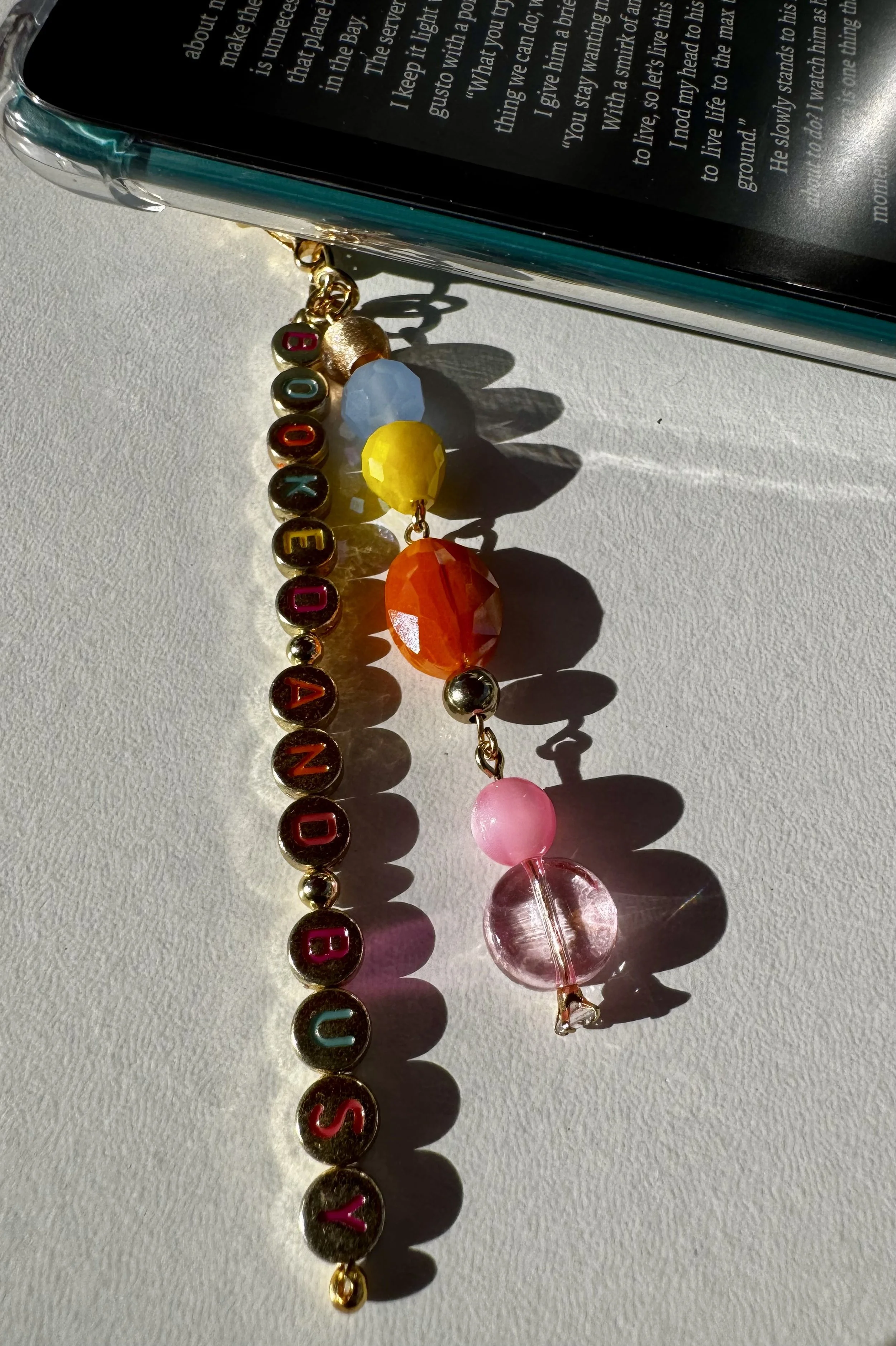 Personalized “Booked and Busy” beaded Kindle charm with colorful gemstones and gold letter beads