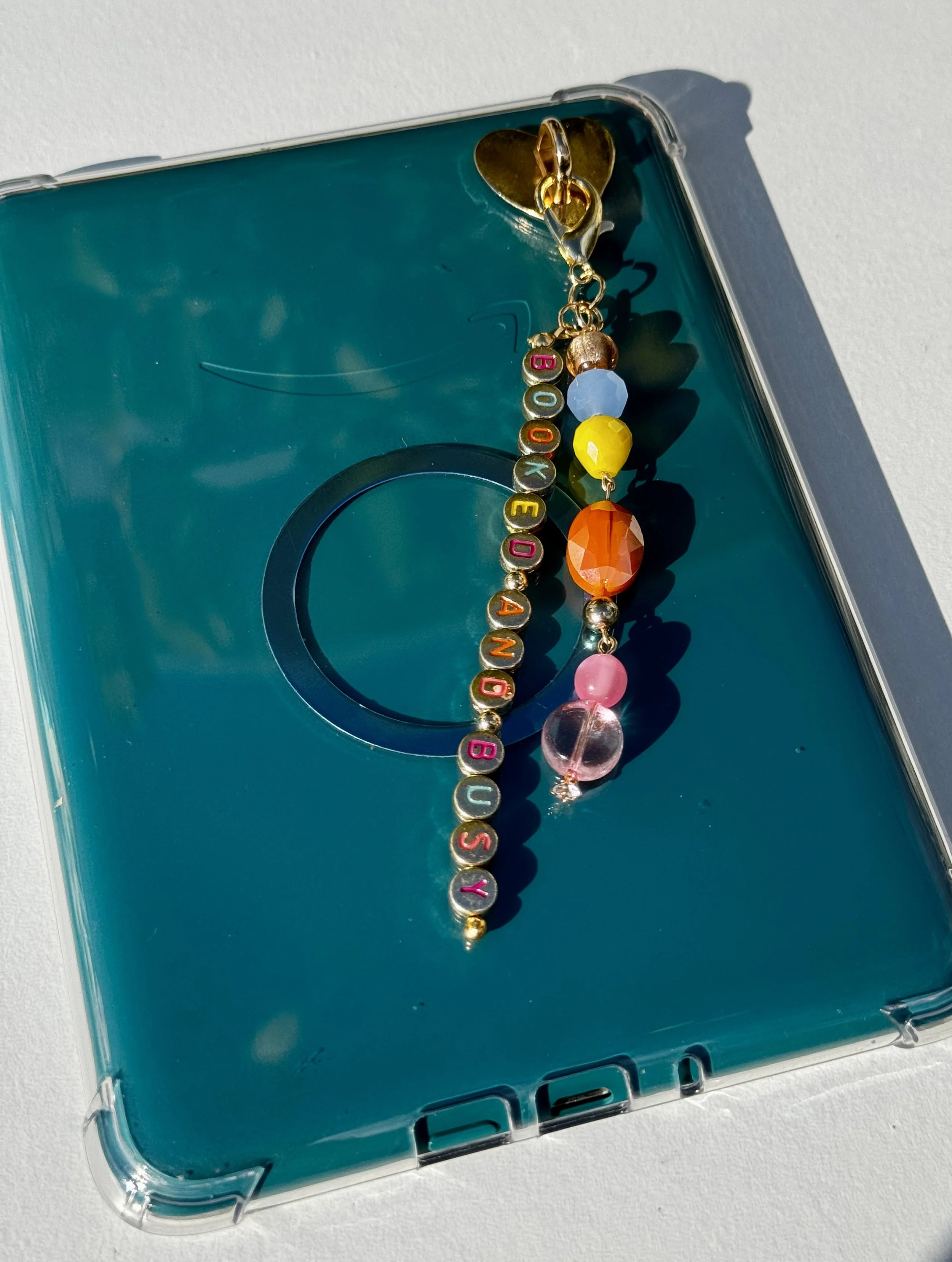Personalized “Booked and Busy” beaded Kindle charm with colorful gemstones and gold letter beads