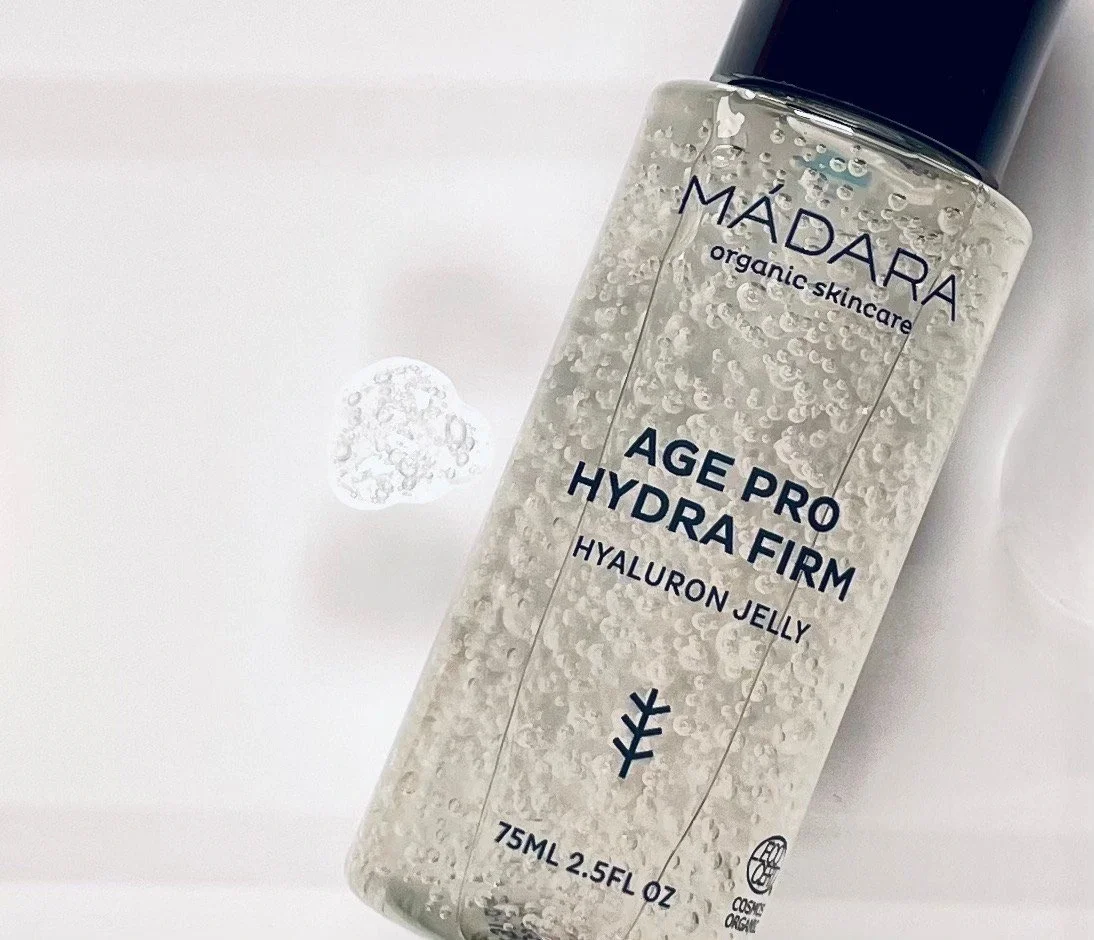 Das Age Pro Hydra Firm Gel von MÁDARA liegt auf einer Fläche, daneben ist ein Klecks vom Gel zu sehen