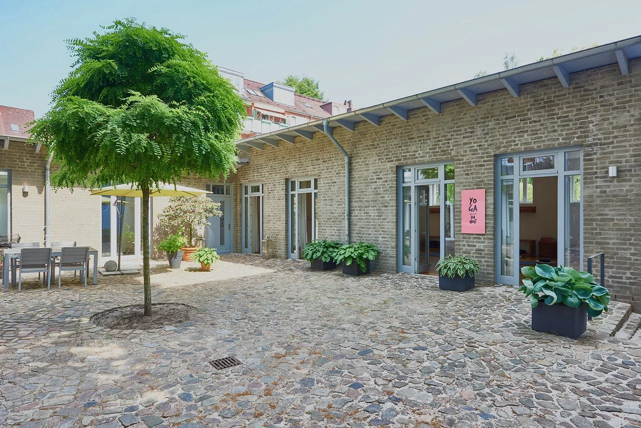 Das Yogastudio "Yoga im Hof" in Barmbek ist heir zu sehen, der gepflasterte Innenhof und die göffneten Türen zum Studio
