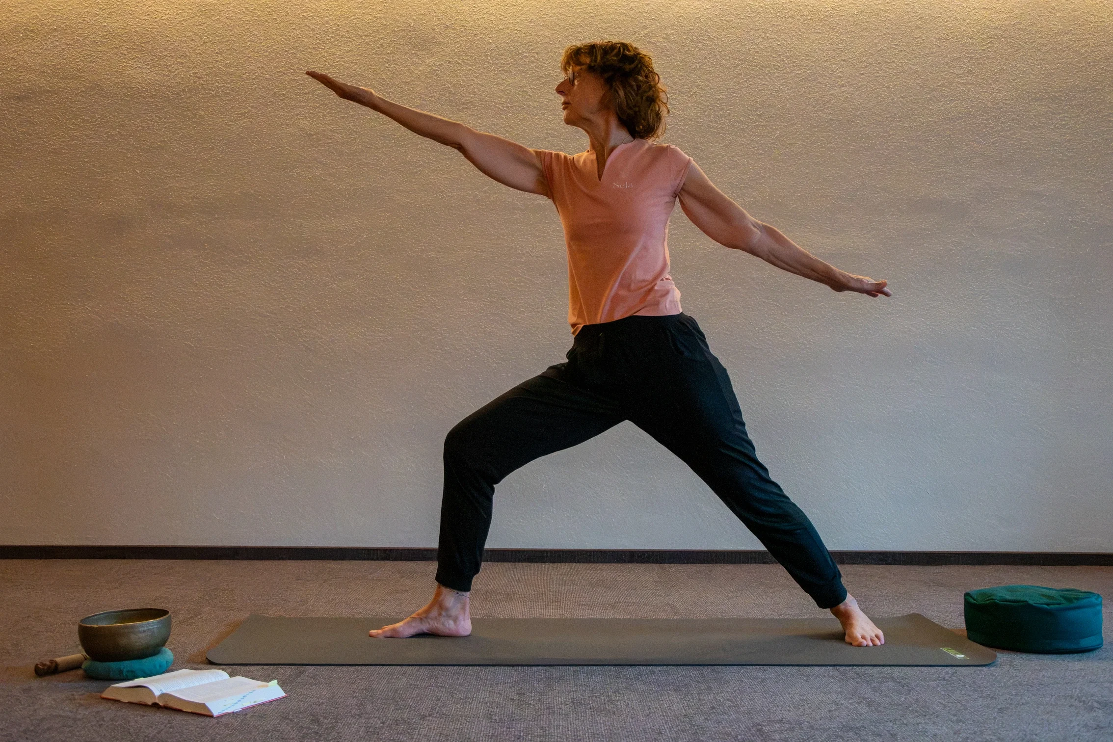 Die Yogalehrerin Maria Schotte ist hier in der Yoga-Pose Krieger zu sehen. Sie praktiziert Christliches Yoga.
