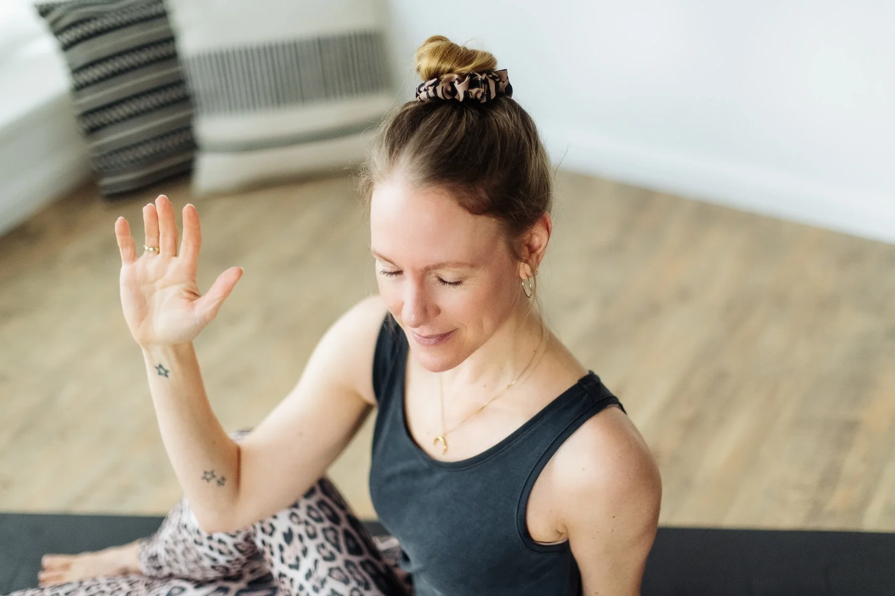 Die Yogalehrerin Astroid Nöhring sitzt im Drehsitz auf einer Yogamatte
