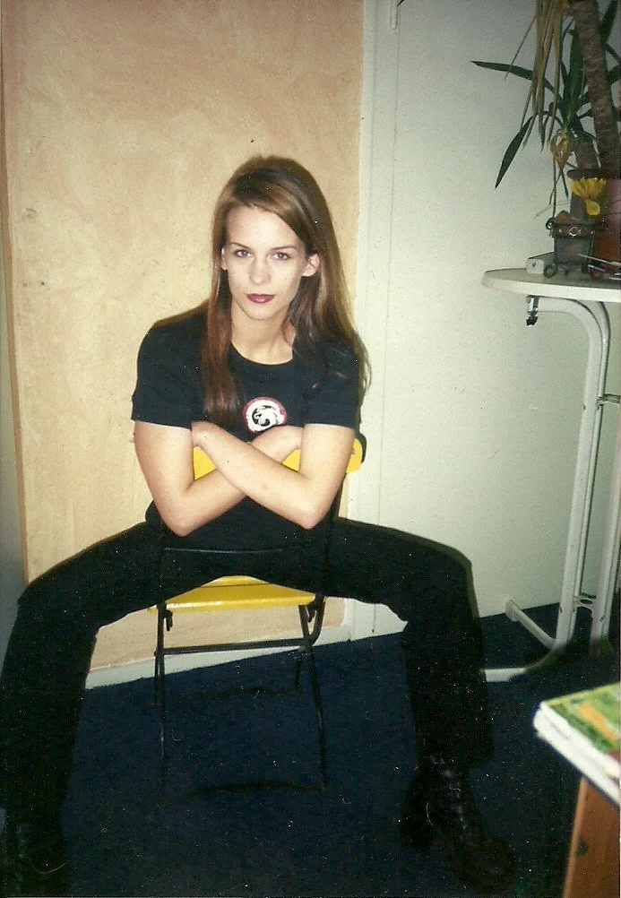 Die Bloggerin Julia Köcher-Eckebrecht von junieundich in den 1990ern sitzt auf einem Stuhl und blickt in die Kamera