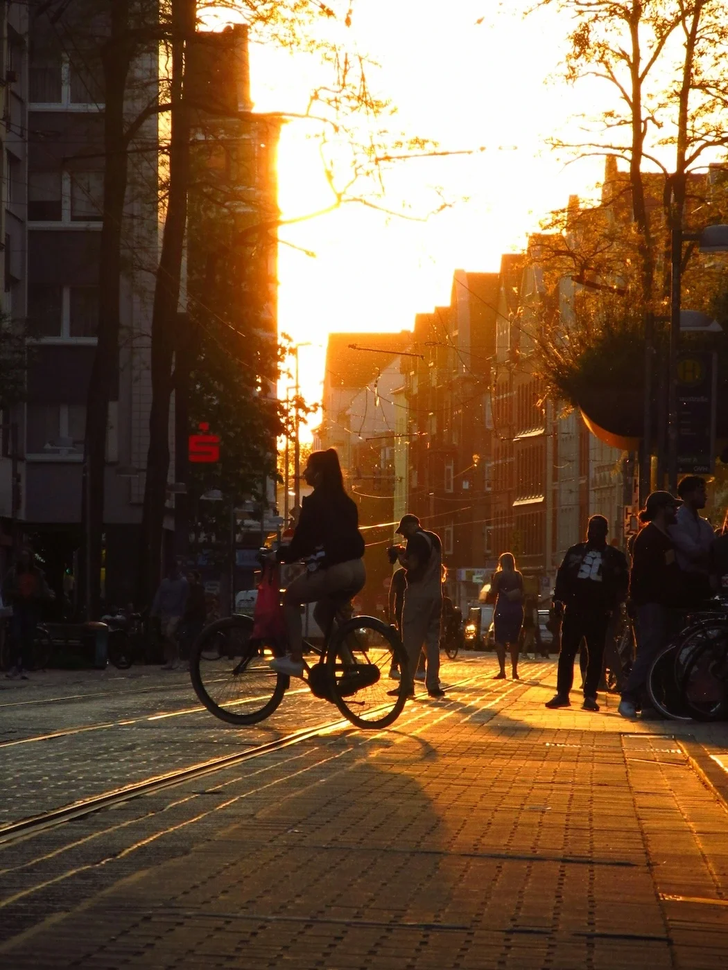 Man sieht eine Straße in Hannover-Linden an einem Sommerabend, Menschen sind auf der Straße unterwegs