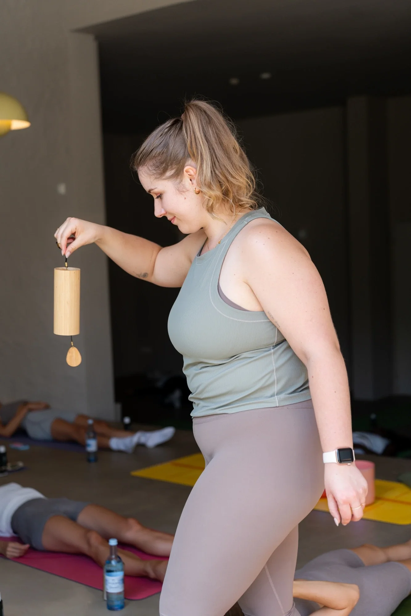 Die Yogalehrerin Lena Jungmann aus Berlin in einer Yoga-Klasse mit einem Holzklanginstrument