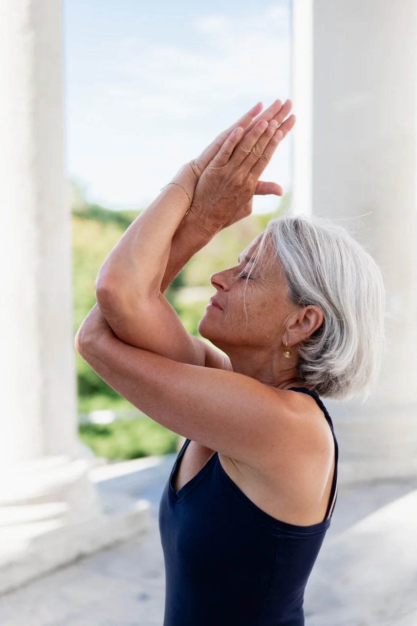 Die Yogalehrerin Sabine Krieger übt die yogische Asana Adlerarme