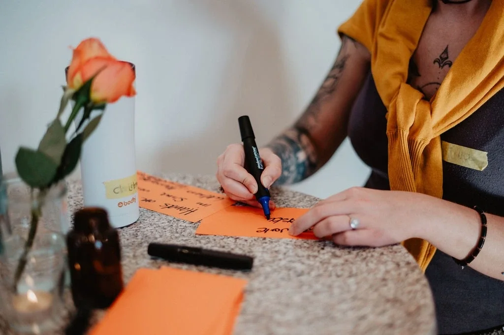 Eine Frau beim Yoga-Teacher-Camp schreibt auf Notizkarten