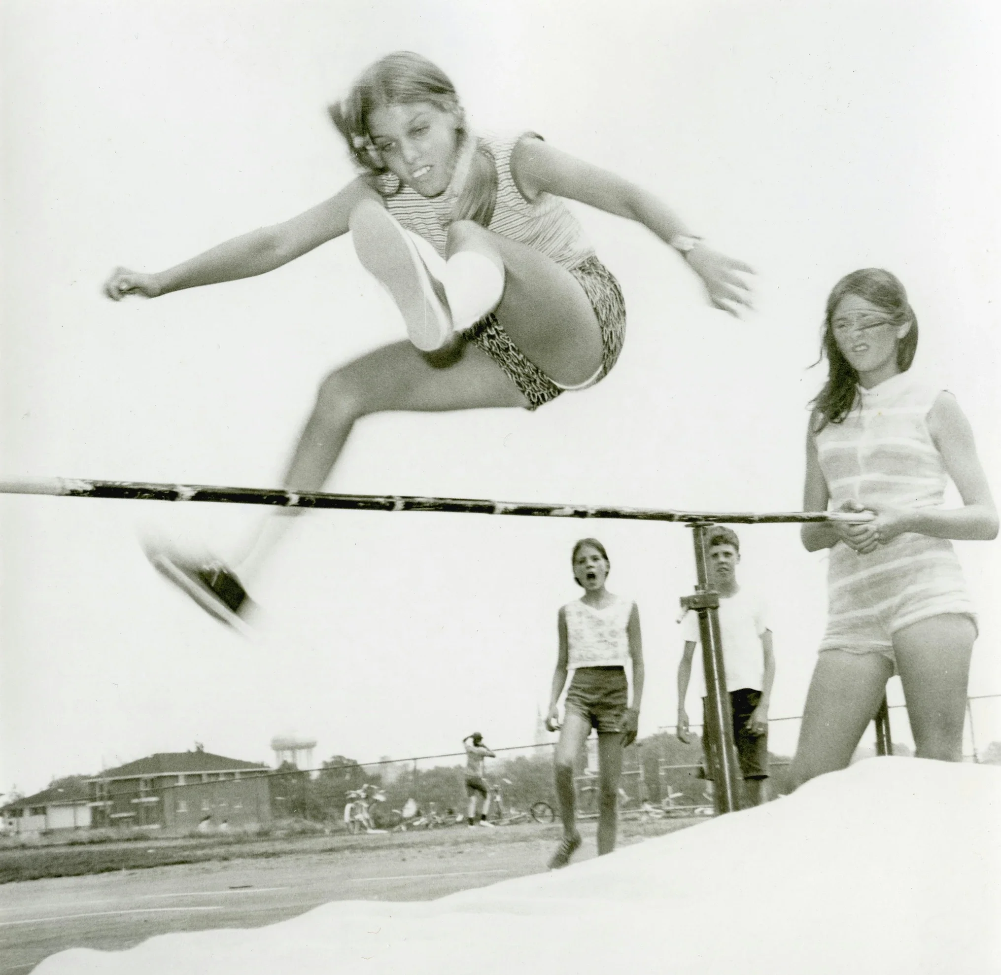 Ein Bild aus den 70er Jahren zeigt junge Mädchen beim Hochsprung in der Schule