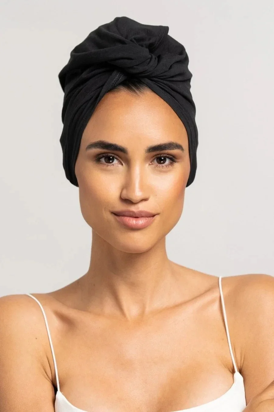 Eine Model trägt einen Haarturban der nachhaltigen Marke Curly’N’Covered zum Haare trocknen und ploppen