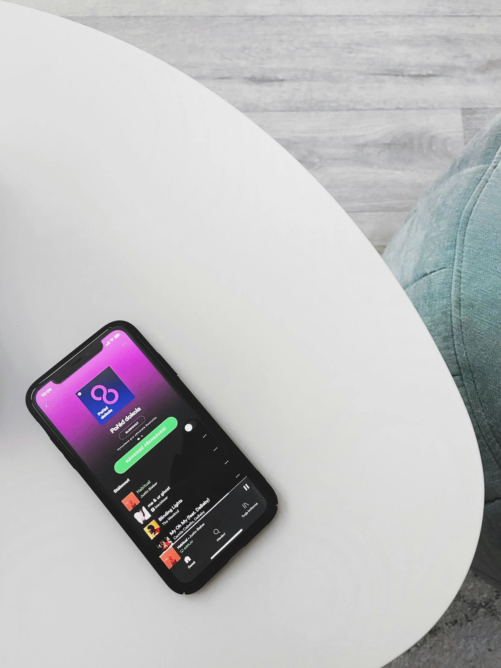 Ein Smartphone liegt auf dem Tisch, auf dem Display erkennt man Spotify, es steht für den hohen Ausstoss an CO2 beim Musikstreaming