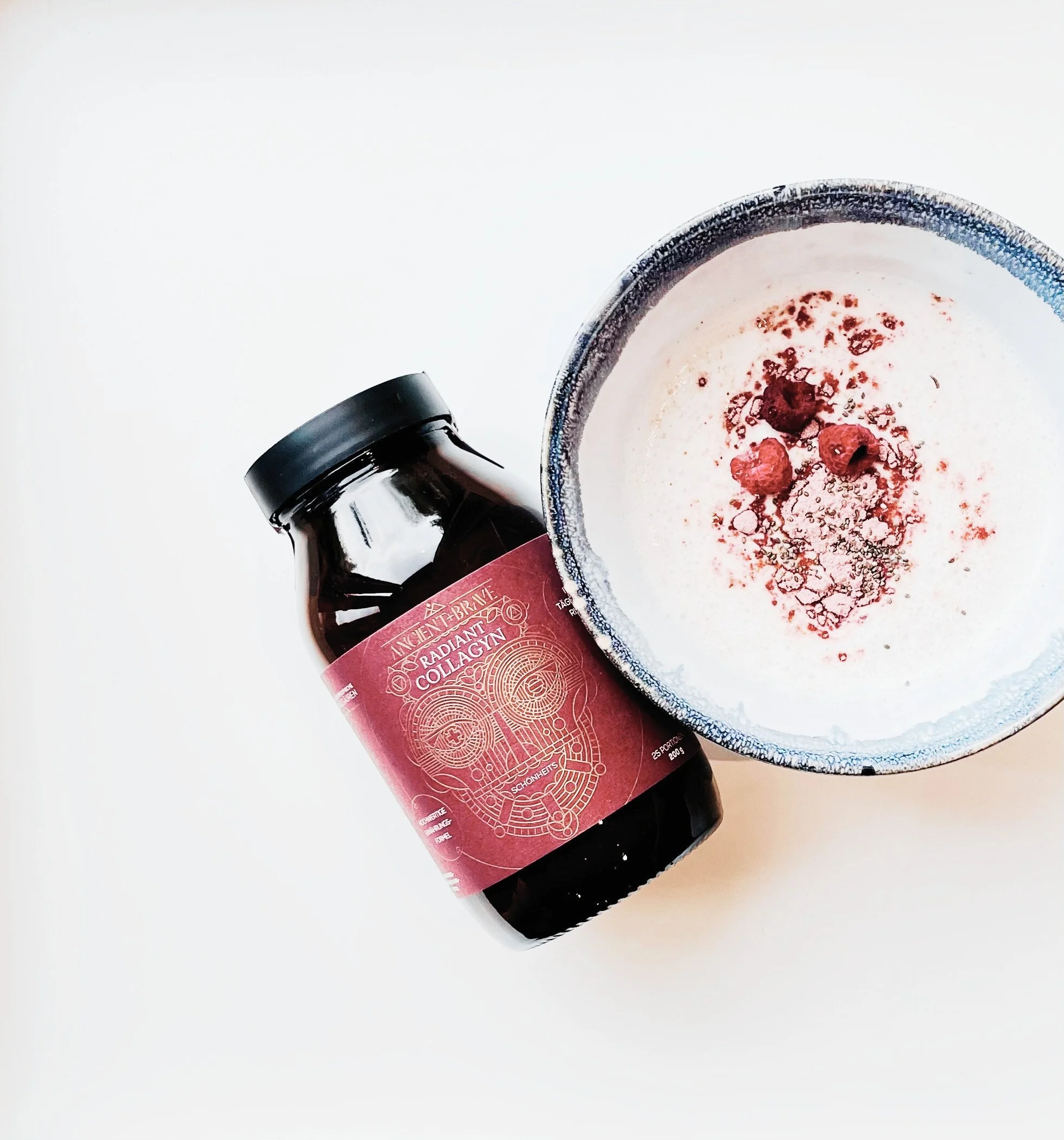 Eine Smoothie-Bowl mit Himbeeren und dem Radiant Collagyn von Ancient + Brave ist zu sehen, das Produkt liegt daneben