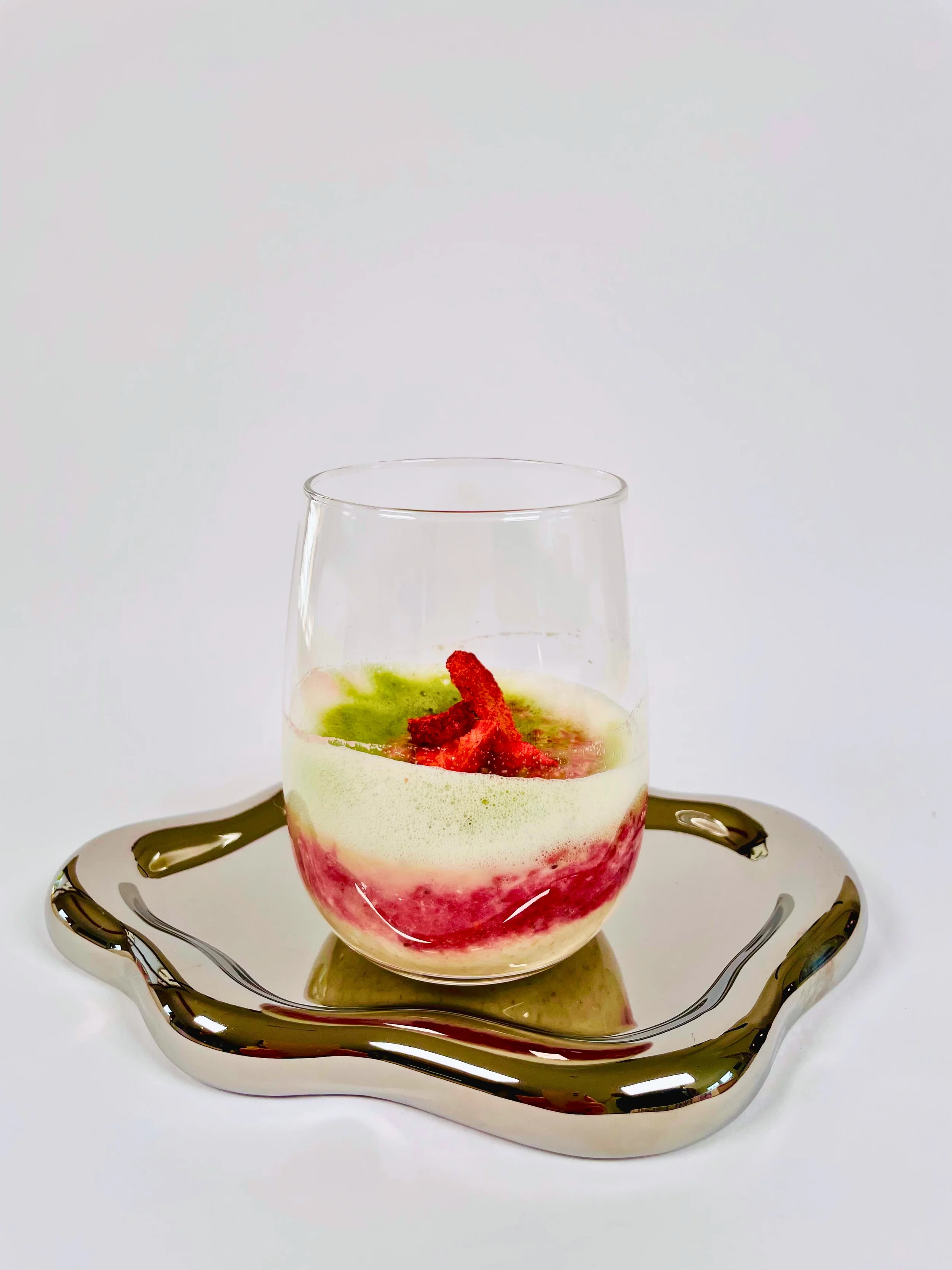 Ein Glas mit einem Matcha-Erdbeer-Latte-Frühstück ist hier zu sehen, darin enthalten ist das Proteinpulver von InnoNature