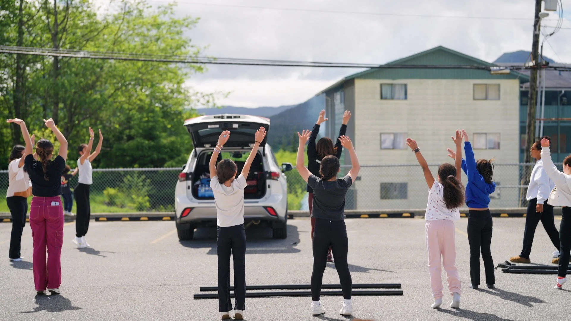 Students learning Philippine folk dance in a parking lot