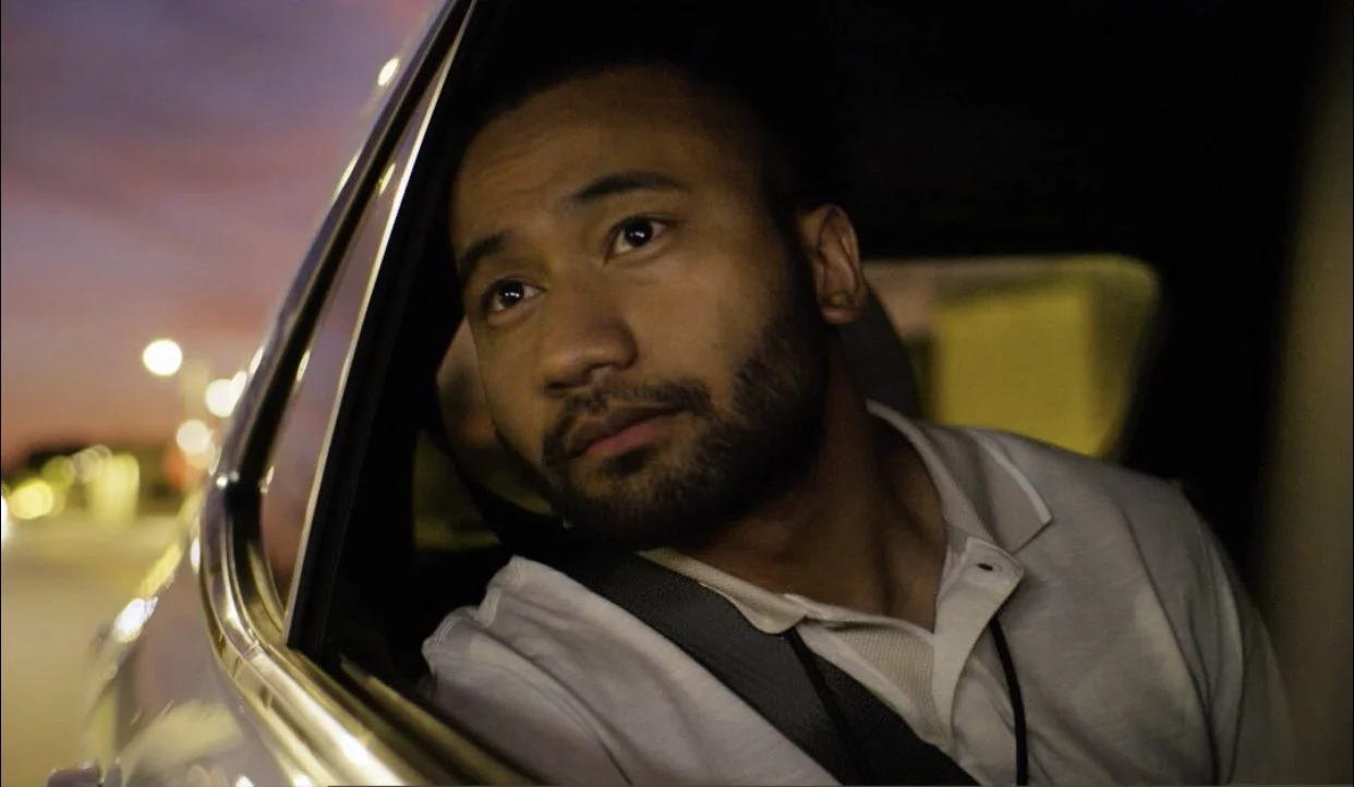 production still of actor Jacob Hawkes in a car looking out