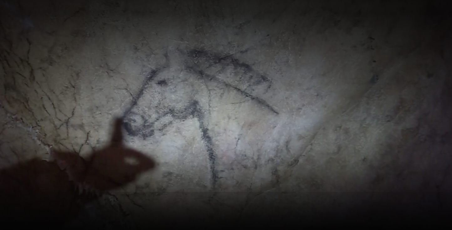 Image of a shadowy finger pointing out features of a horse drawing in Tito Bustillo