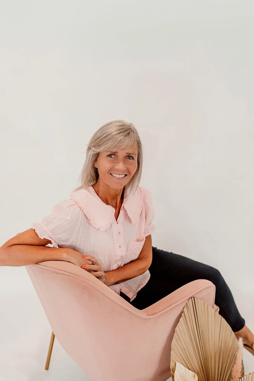 Shelly A., operational manager at The Wedding Bell in Tacoma, posing with elegant wedding dresses.