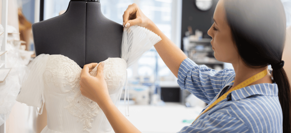 bridal gown fitting with designer adjusting wedding dress details