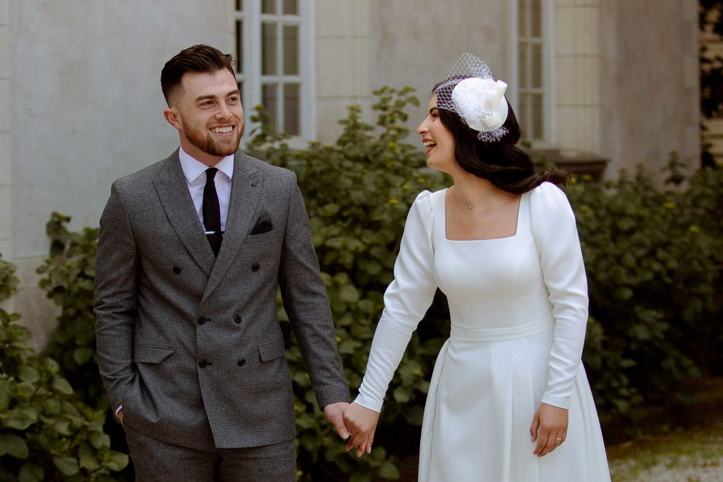 Couple de jeunes mariés qui se tiennent la main et sourient