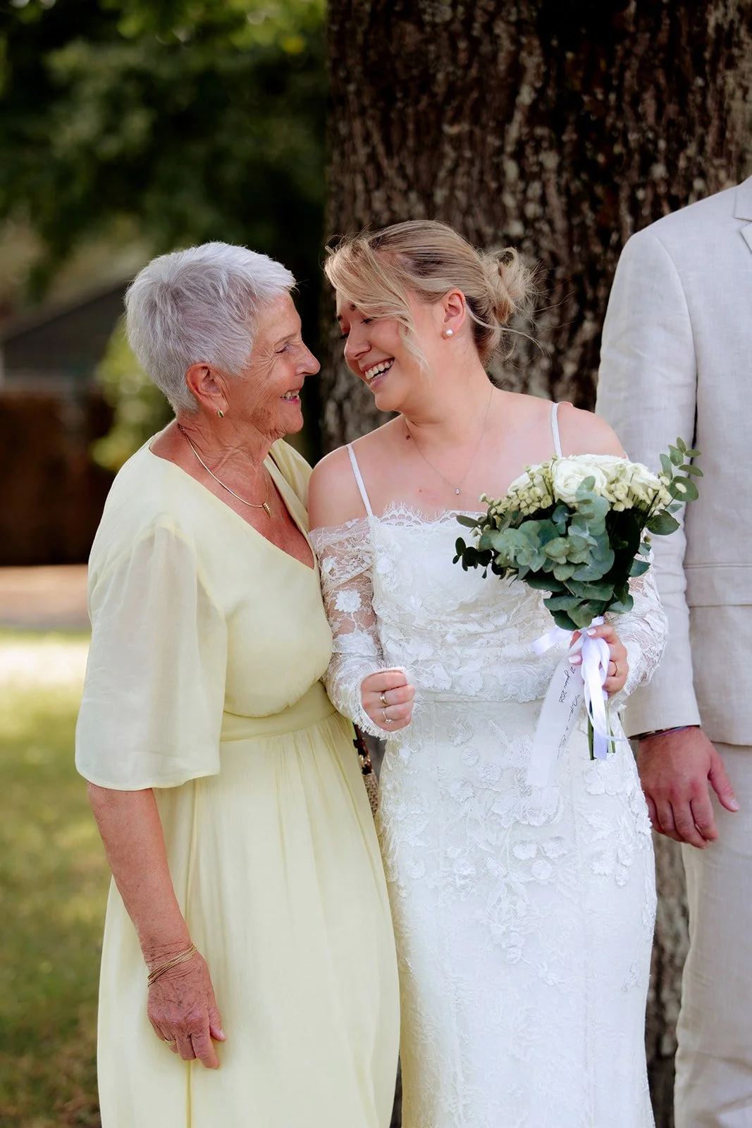 une mariée et sa grand-mère se regardent en souriant complices