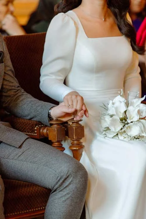 détail d'un couple de mariés qui se tiennent la main