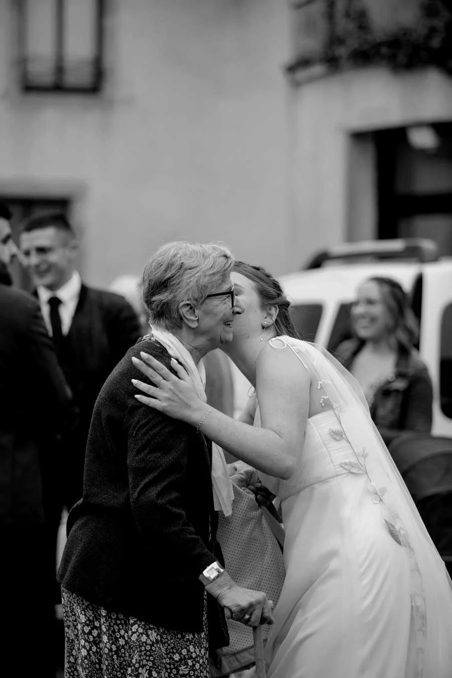 photo en noir et blanc d'une mariée qui embrasse sa grand-mère sur la joue