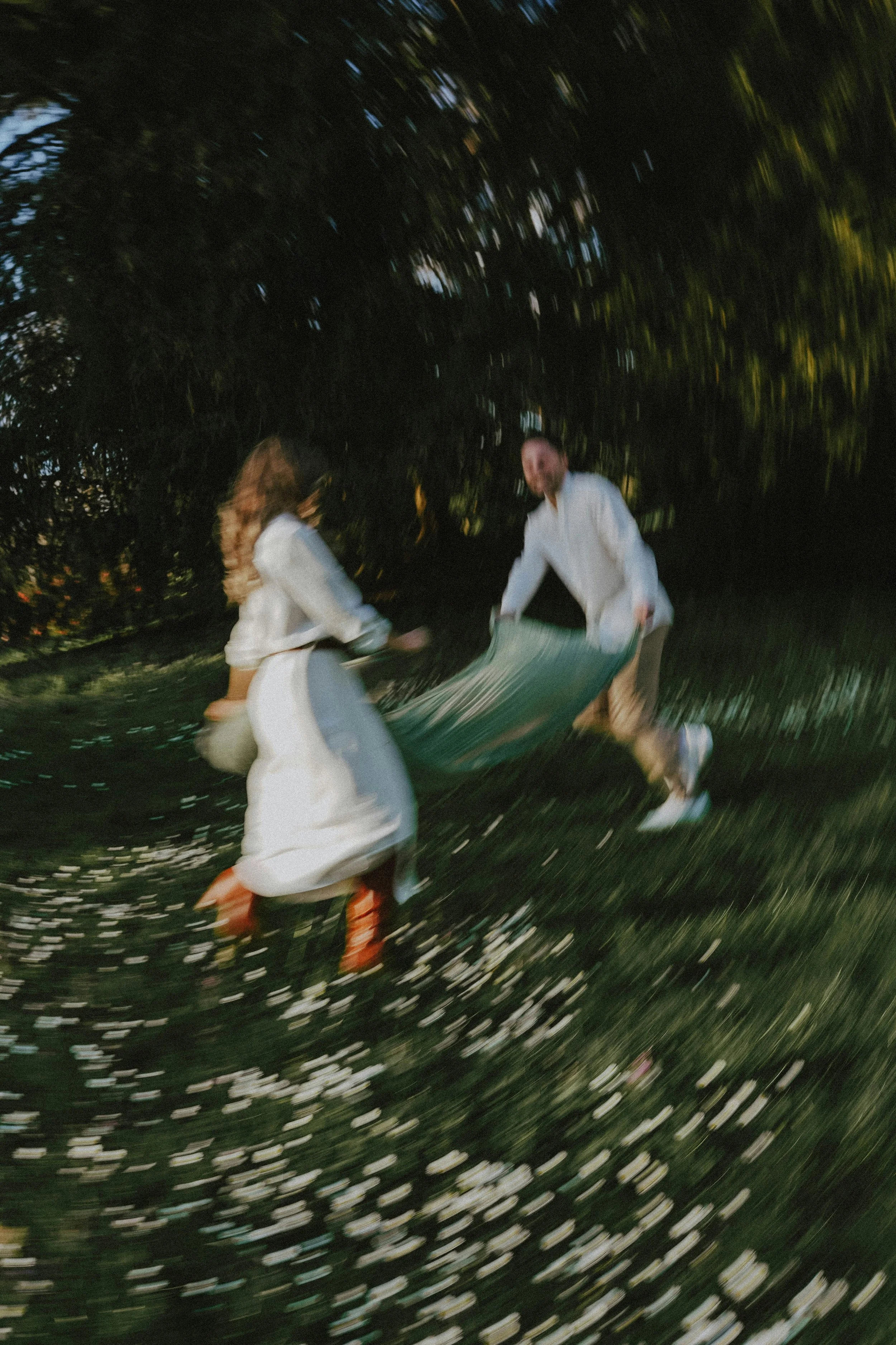 Distorted and blurry image of a couple laying down a blanket in the grass