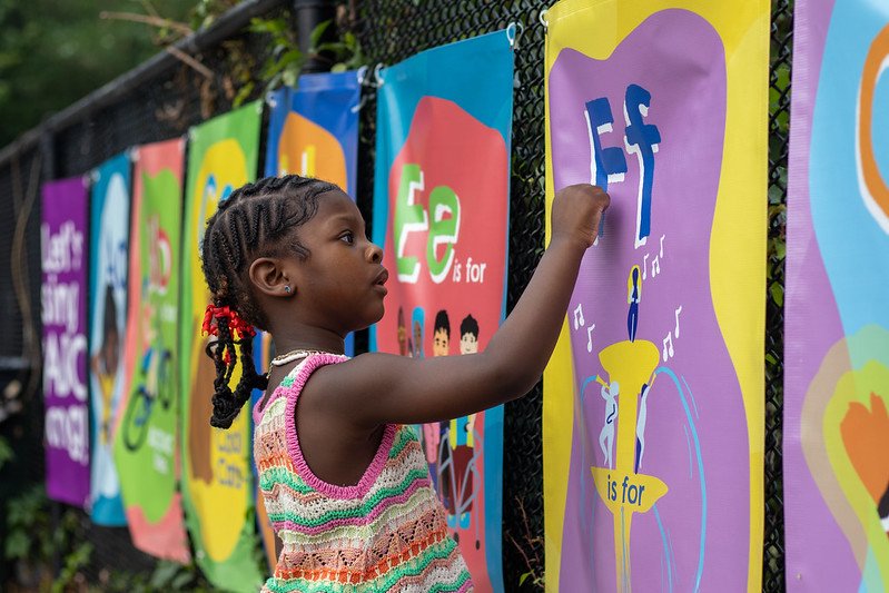 Girl traces letters at Philly ABCs installation at Mander Playground