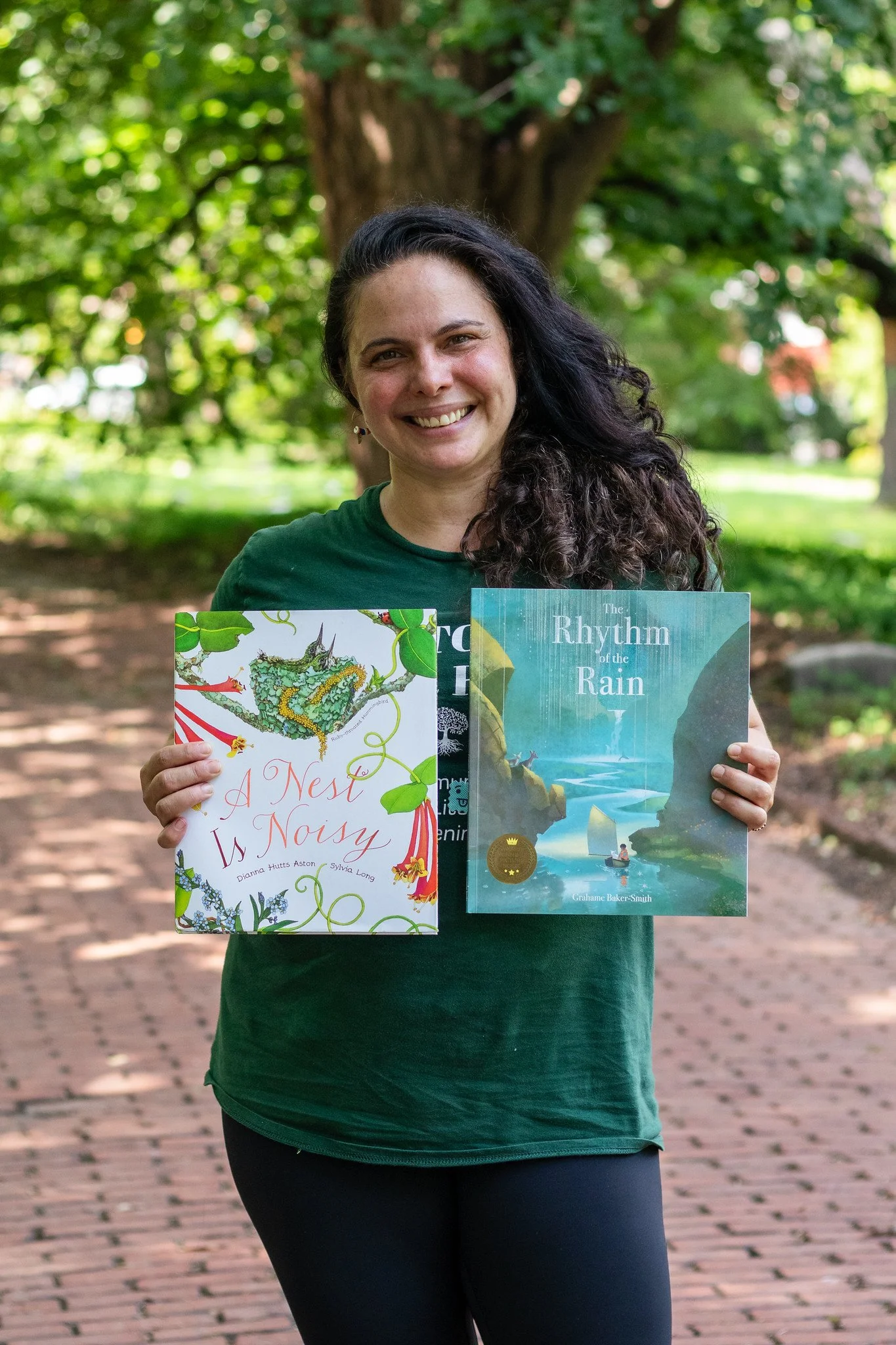 Martina Barbour smiles while holding two books shared during storytime.