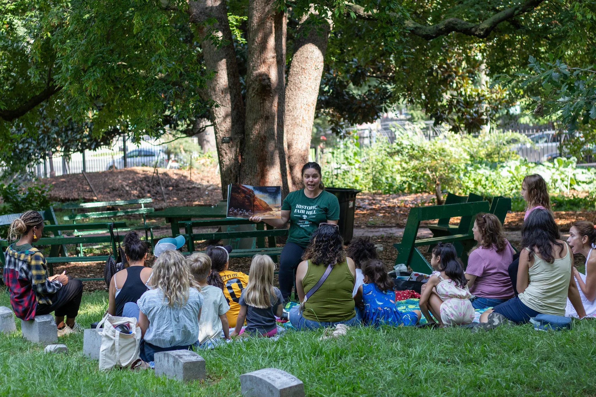 Families gather close, listening as Martina Barbour shares a story at Historic Fairhill.