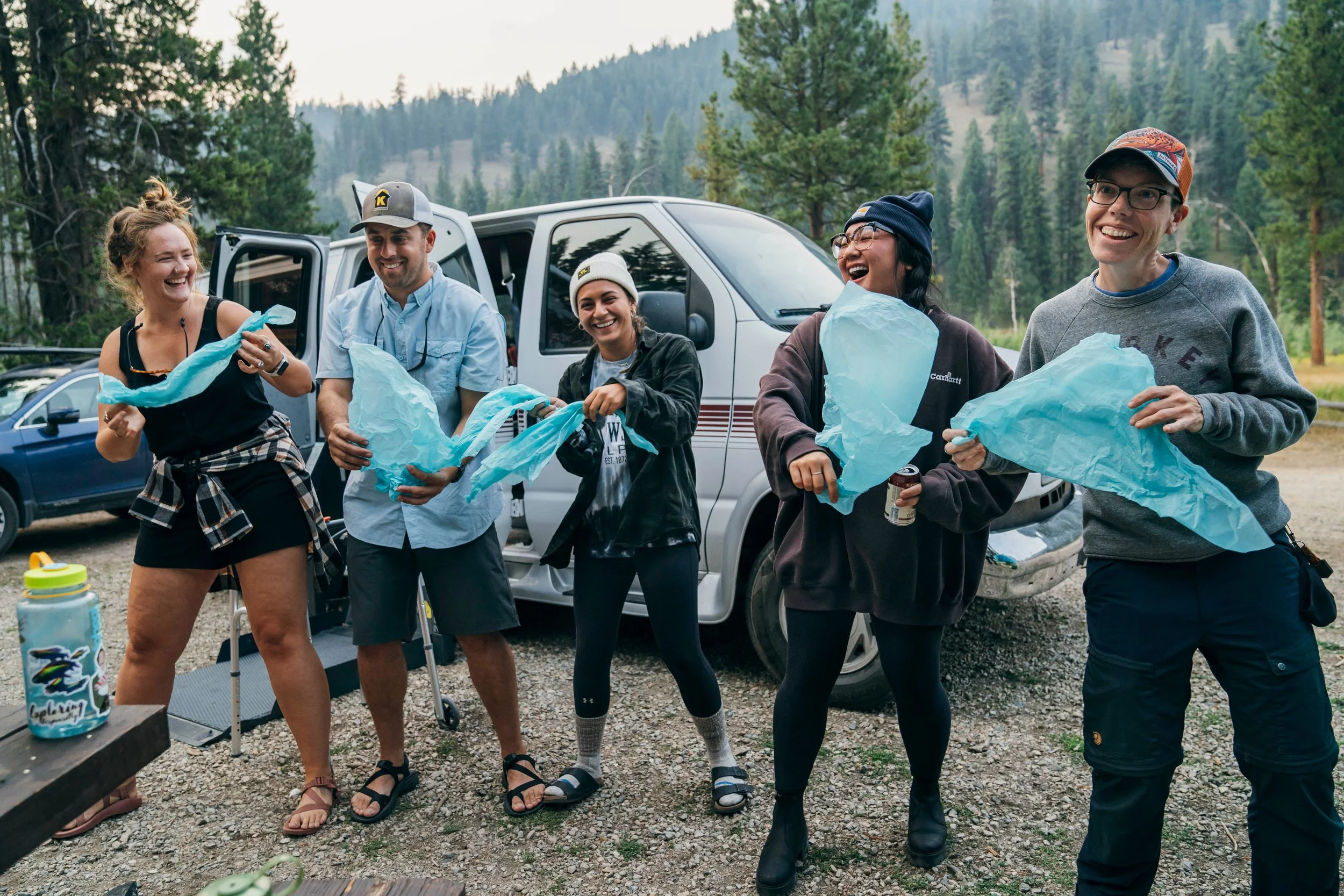 campers smile and laugh during opening night activities  with tissue paper in hand to create a team mascot