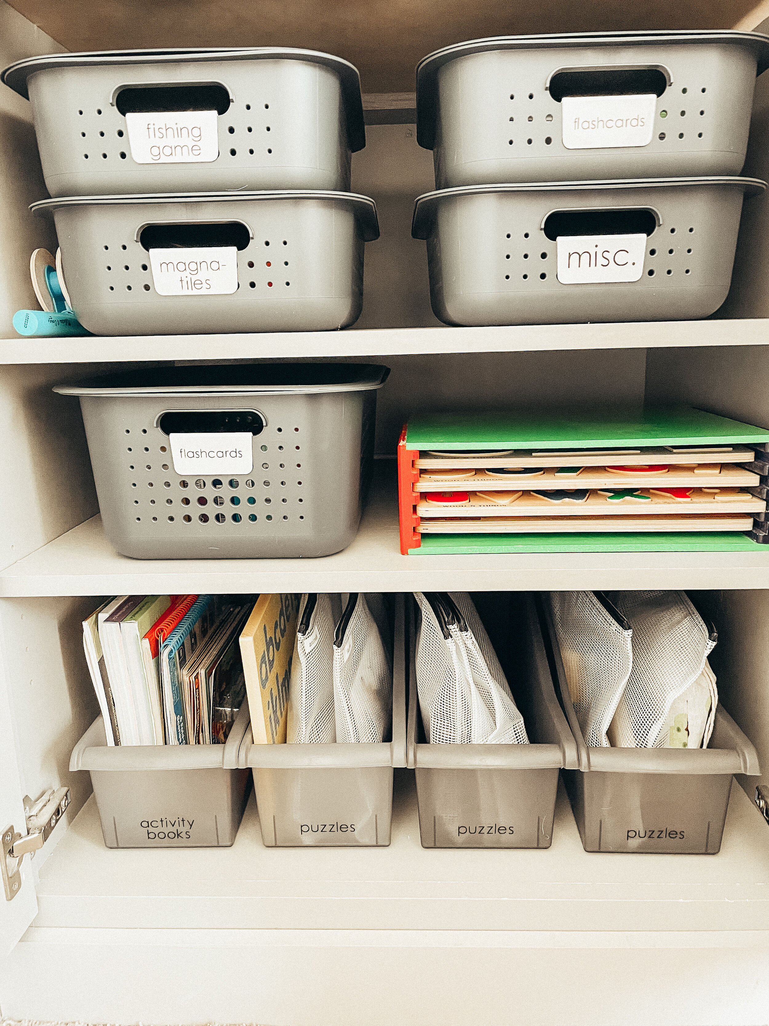 Organized storage closet with grey plastic bins