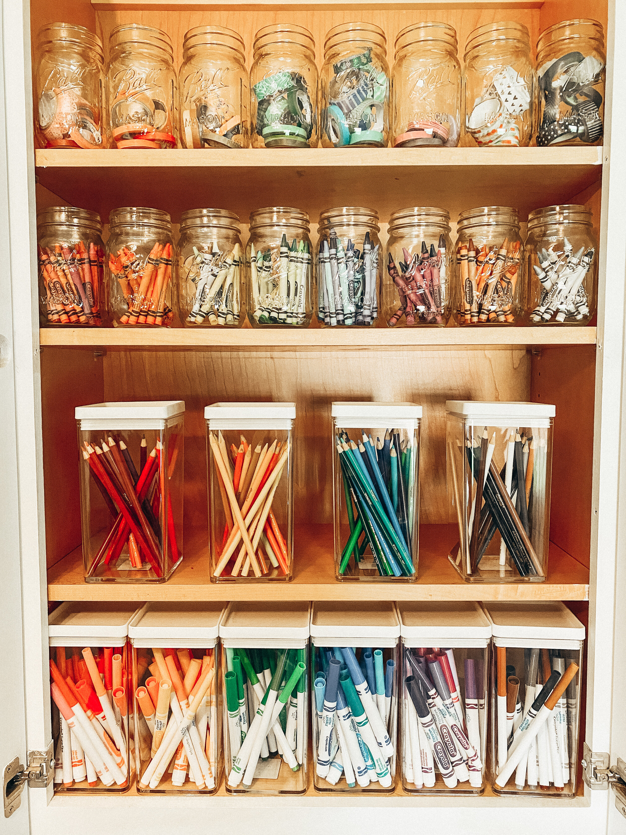 Art supply closet organized with jars by Stay Golden Organizing