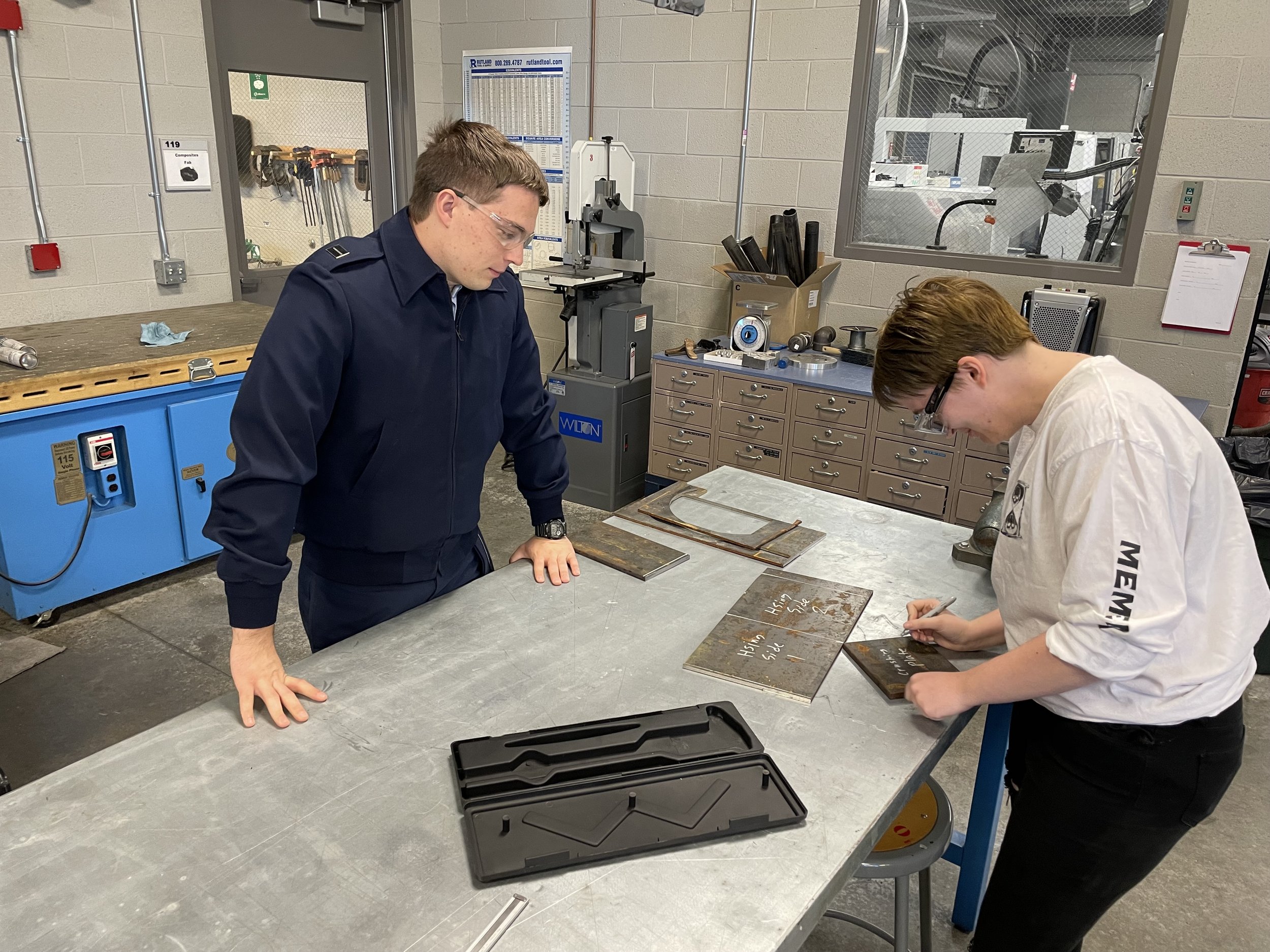 Justin Evans (left) and Grey Trotter (right) in the machine shop, labeling parts before wrapping up for the day.