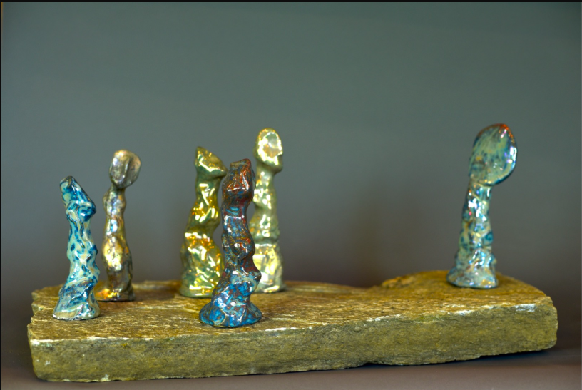 Incomplete Indoctrination, 2025, earthenware + in-glaze reduction luster + granite base, 9 x 24 x 14"