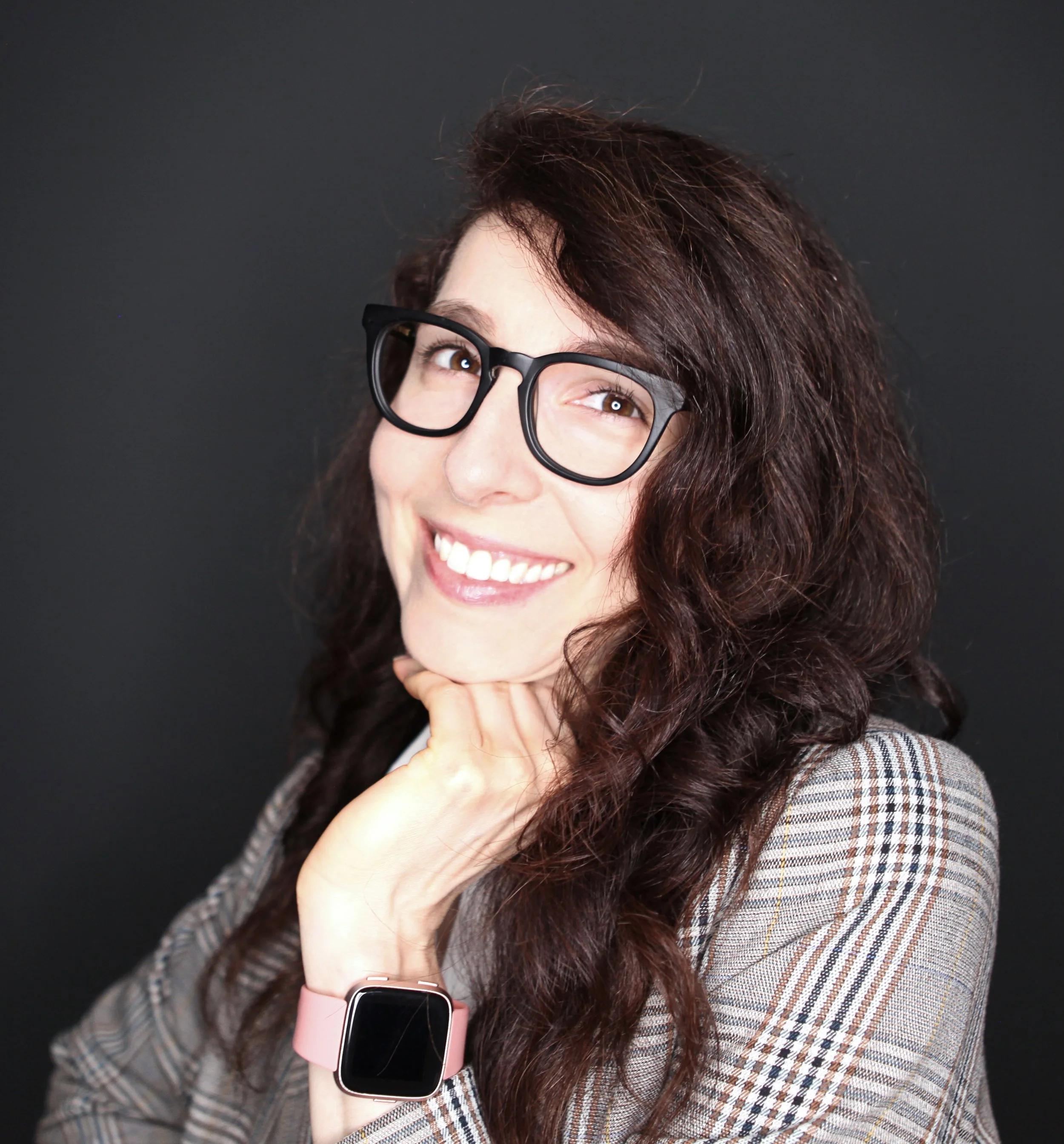 An image of Christina Faulkner with glasses & a watch smiling.