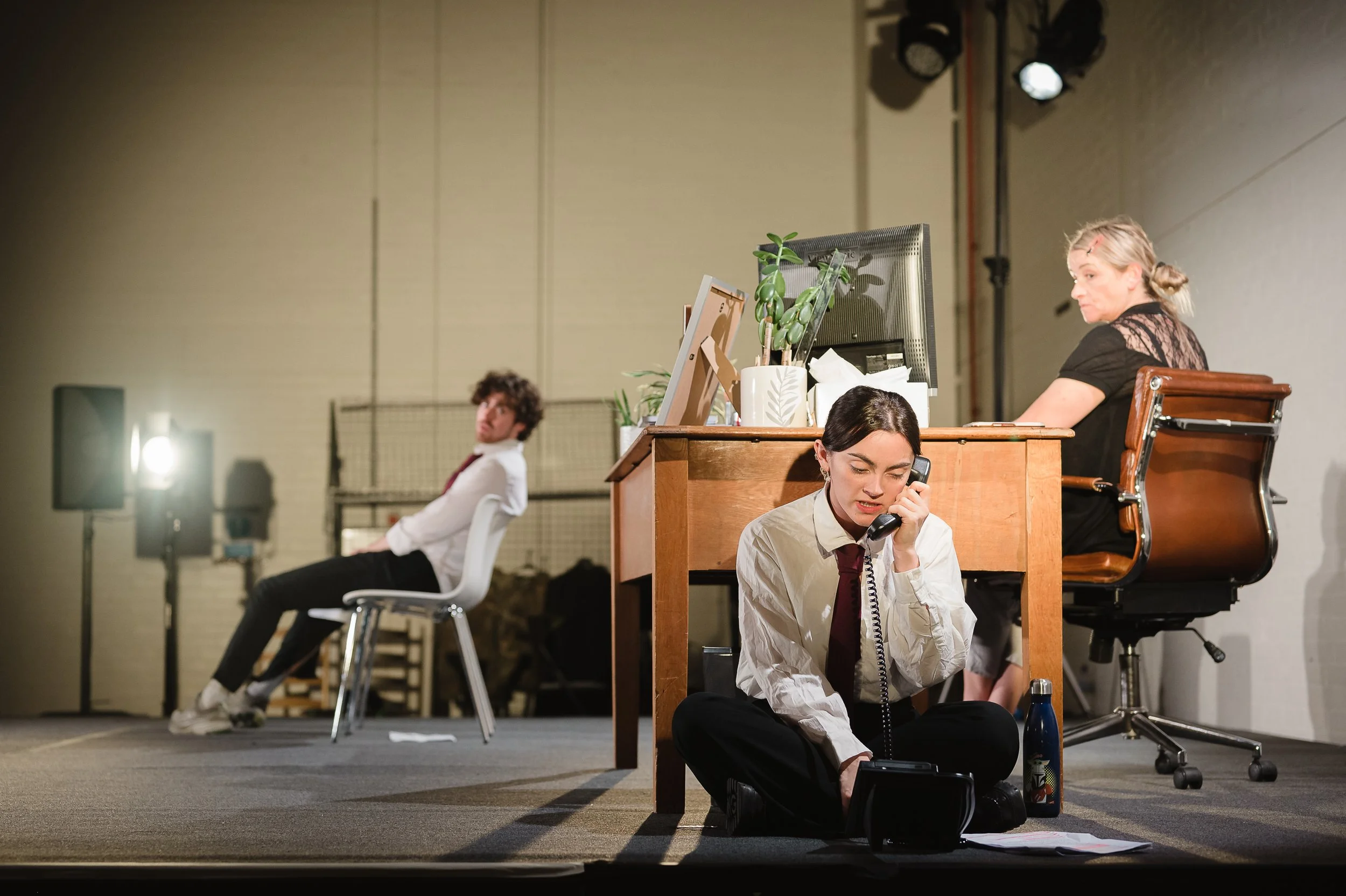 Image © Emma Hare. Three actors, two in school uniform. Two sit by a desk, one is behind it. Image from House on Fire